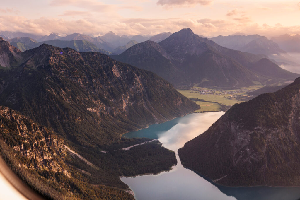 Alpensee zwischen Bergen im Abendlicht als Panorama-Erlebnis