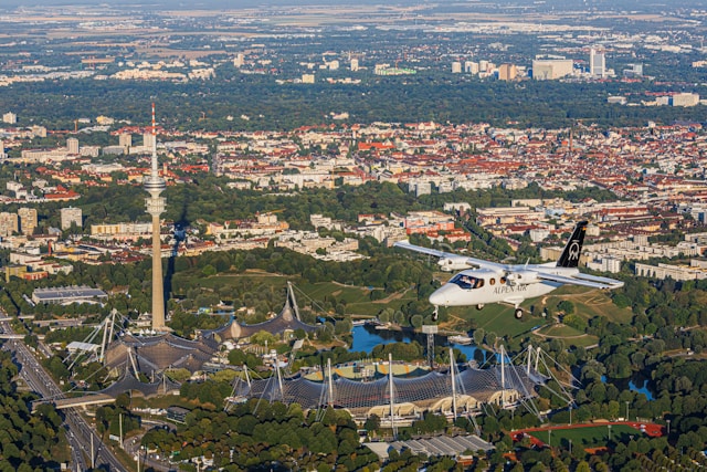 ALPEN AIR Flugzeug über Olympiapark und Stadtlandschaft