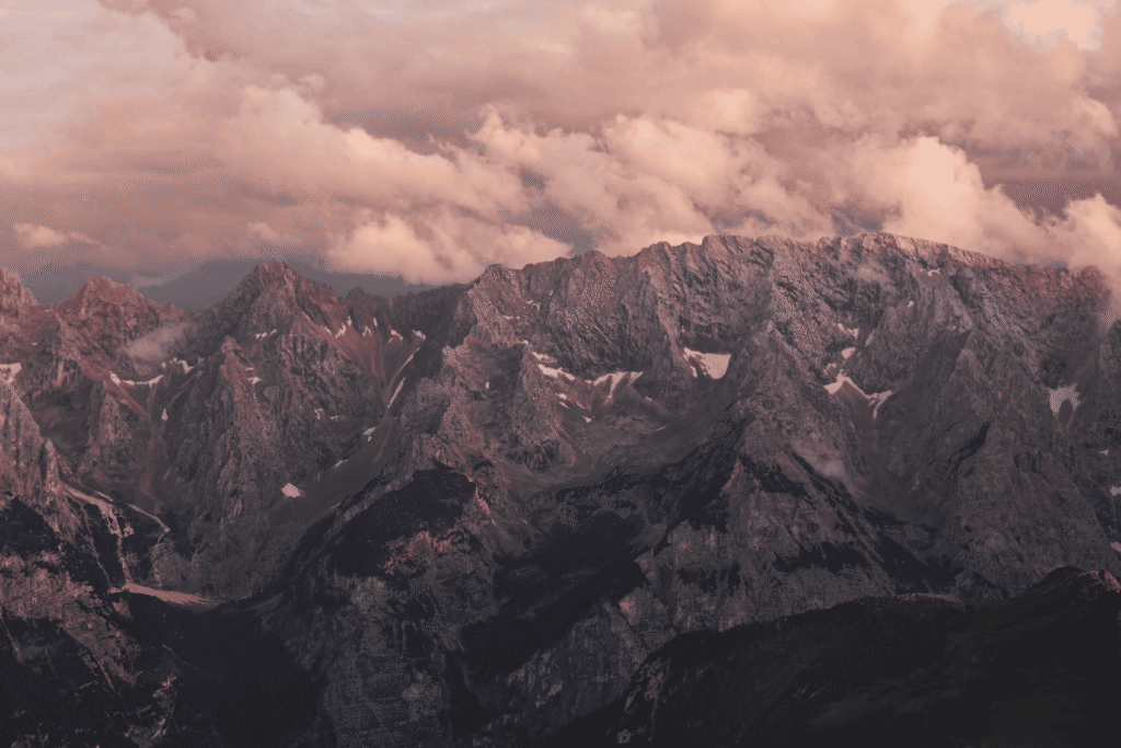 Alpenrundflug über Felsmassiv und Wolken bei wechselnder Sicht