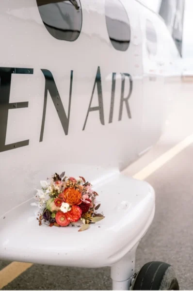 Marriage Proposal Neuschwanstein with bouquet beside an ALPEN AIR aircraft