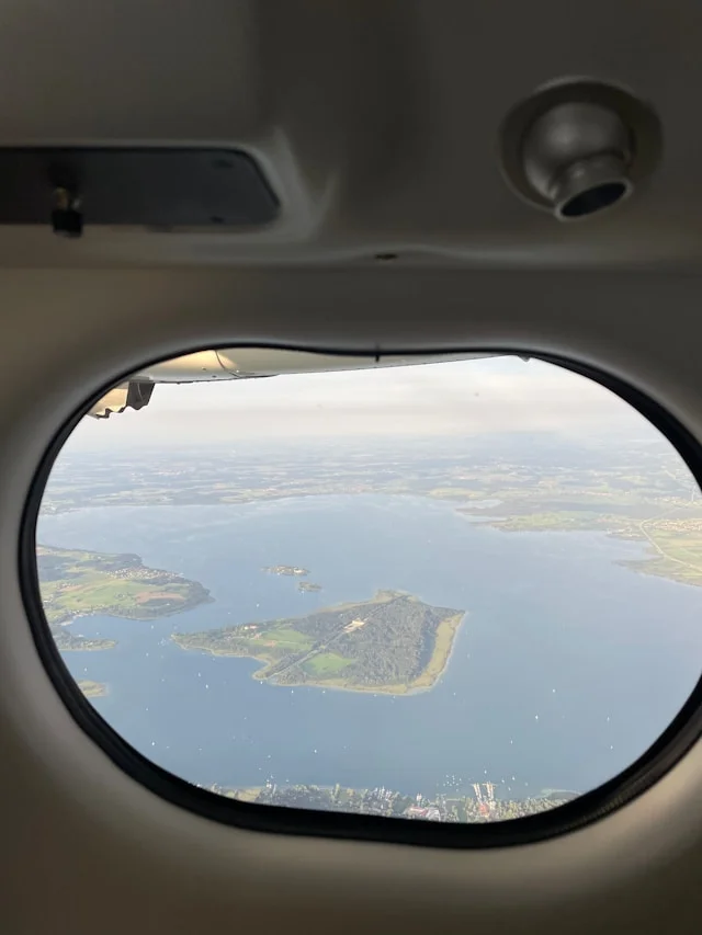 Window view during a sightseeing flight over lake and islands in Bavaria