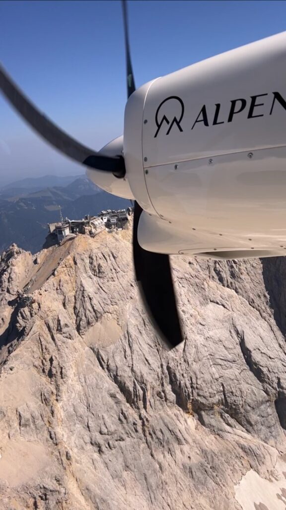 ALPEN AIR Flugzeug nahe felsigem Alpenmassiv bei einem Alpenrundflug