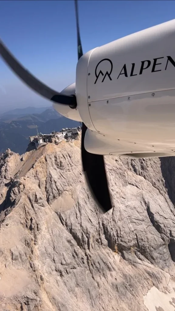 ALPEN AIR aircraft near rocky Alpine massif during an Alps sightseeing flight